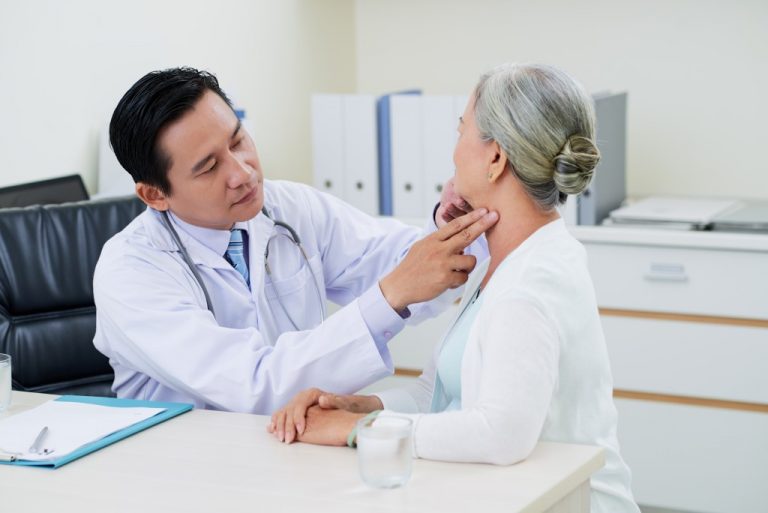 doctor checking neck of woman