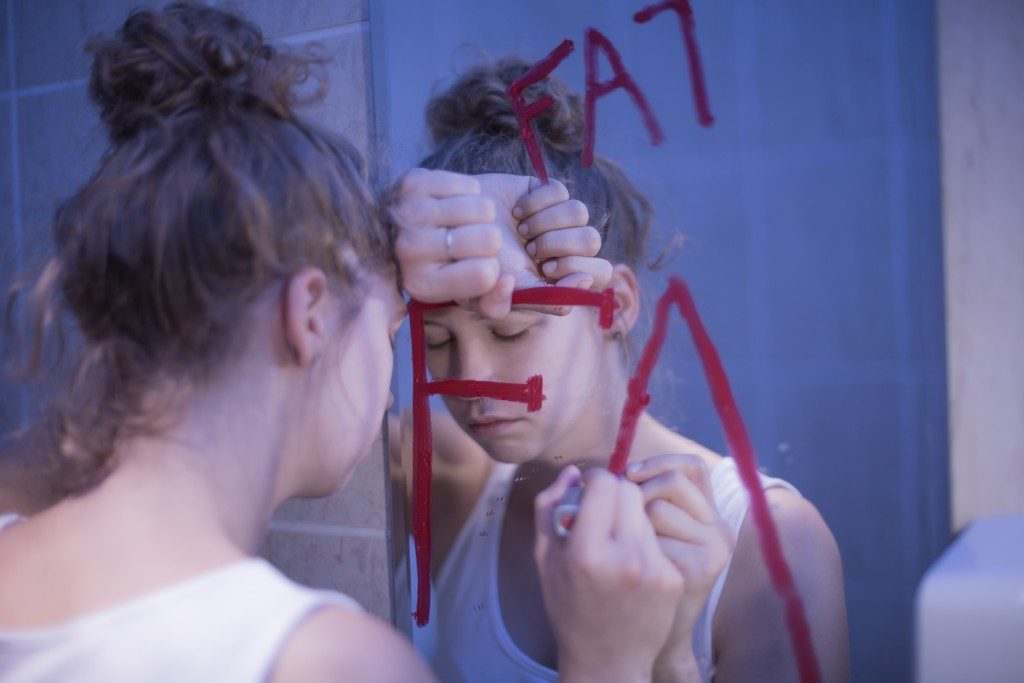 woman facing the mirror having a mental illness 