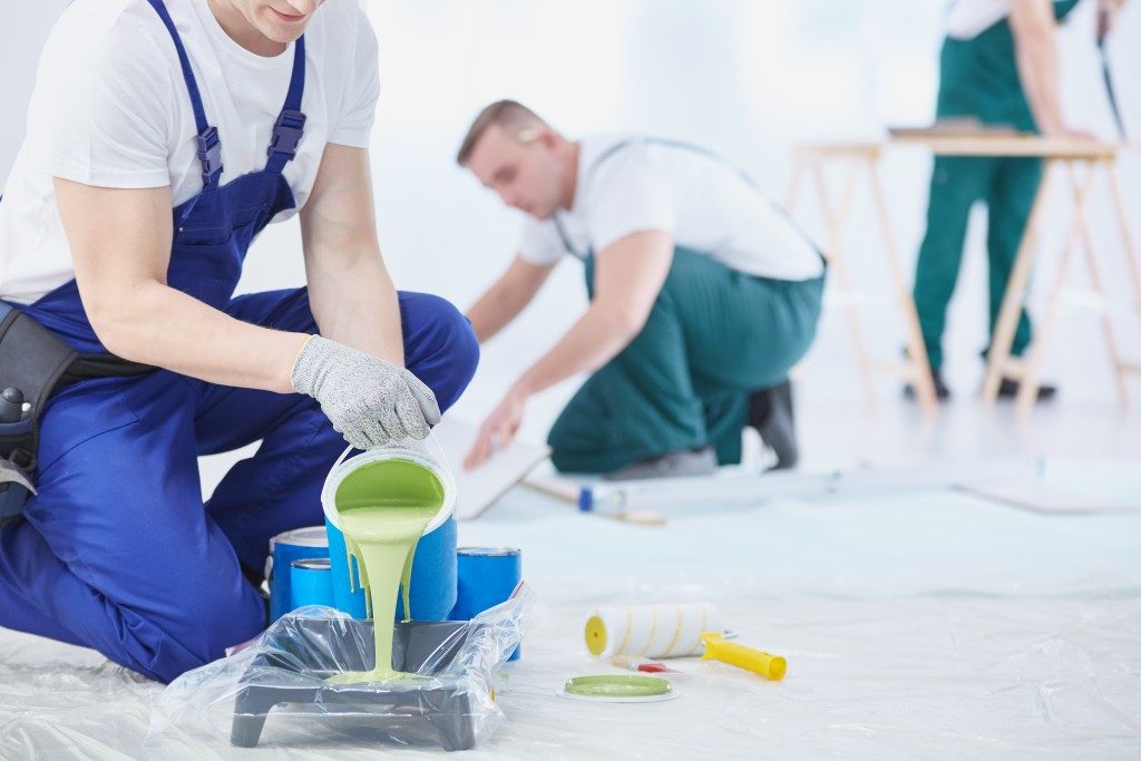 man pouring paint into the pan