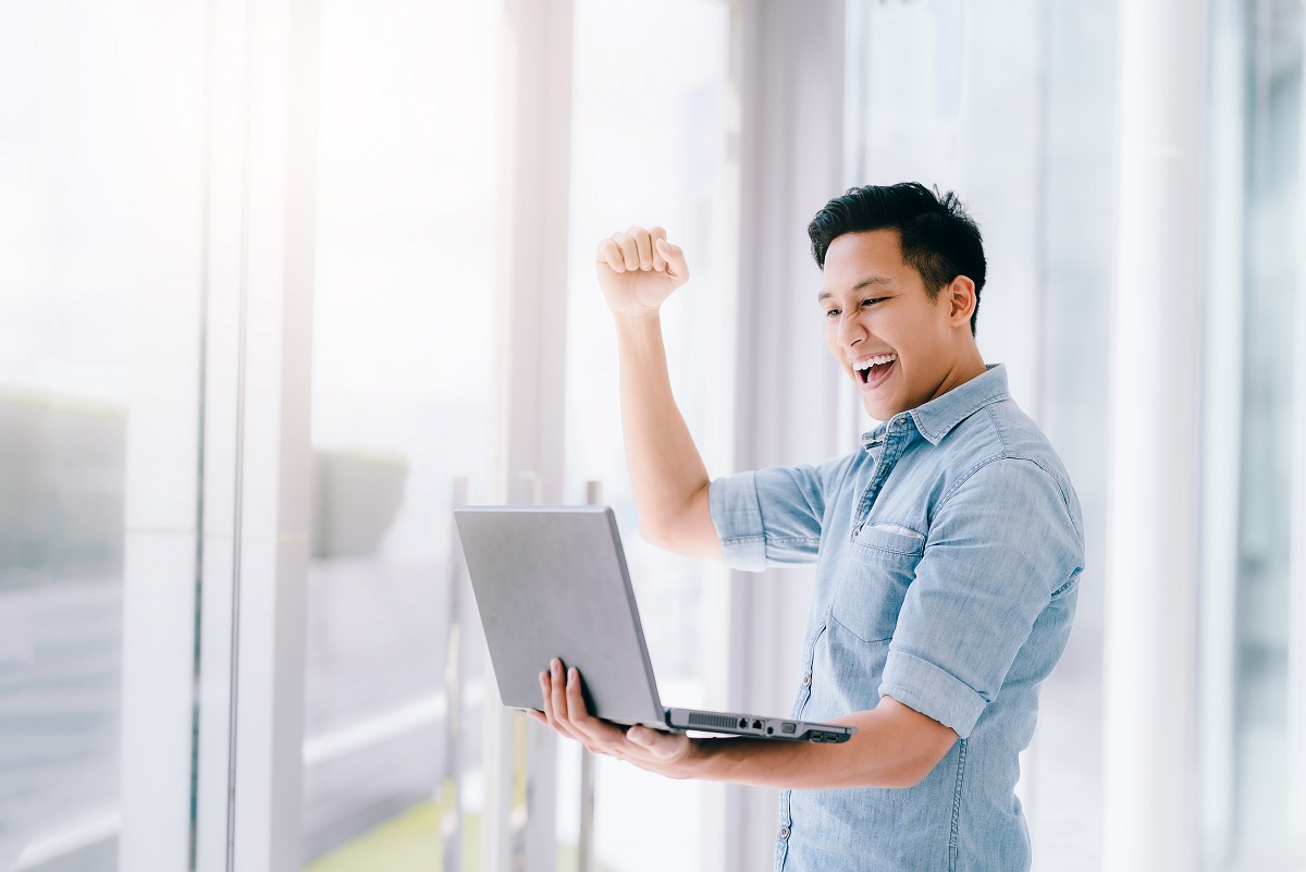 happy guy looking at his laptop