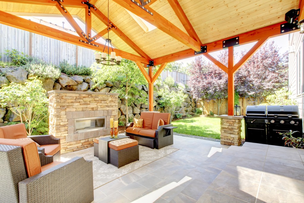 Exterior covered patio with fireplace and furniture