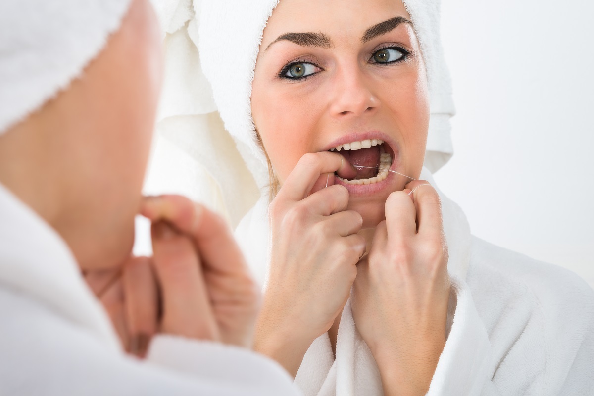 woman flossing her teeth