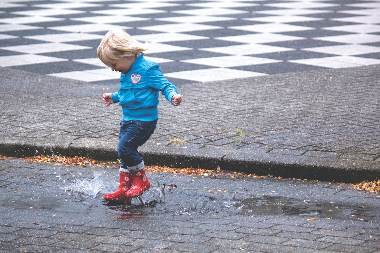 child playing in the rain puddle