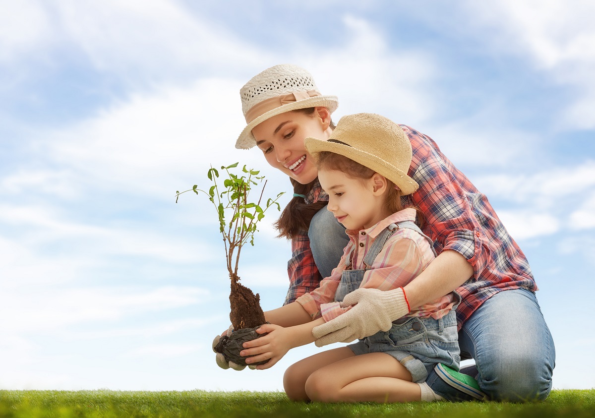 mother and daughter planting a tree