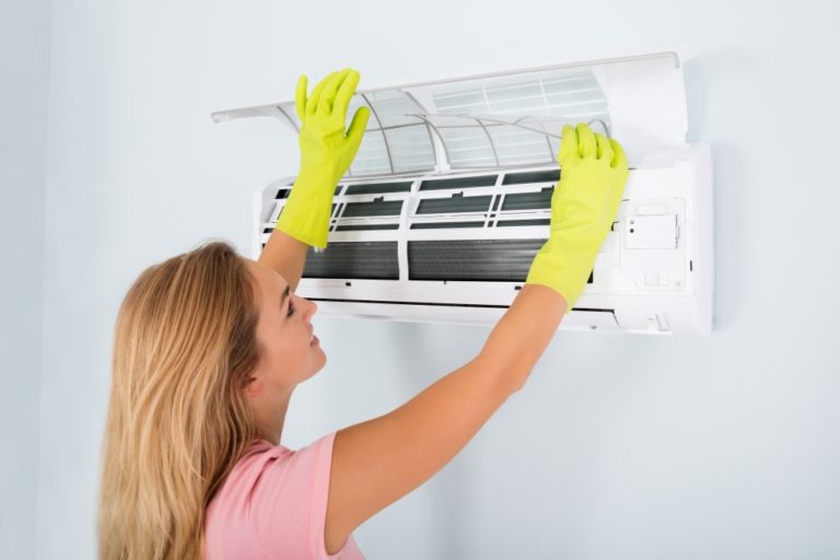woman cleaning air conditioning unit