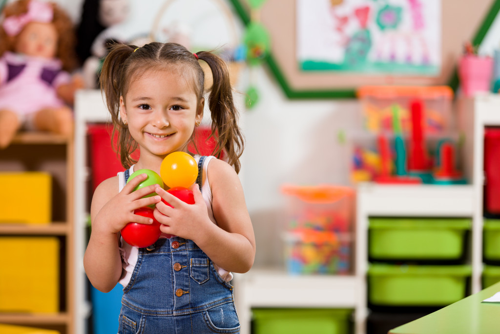 little girl holding balls