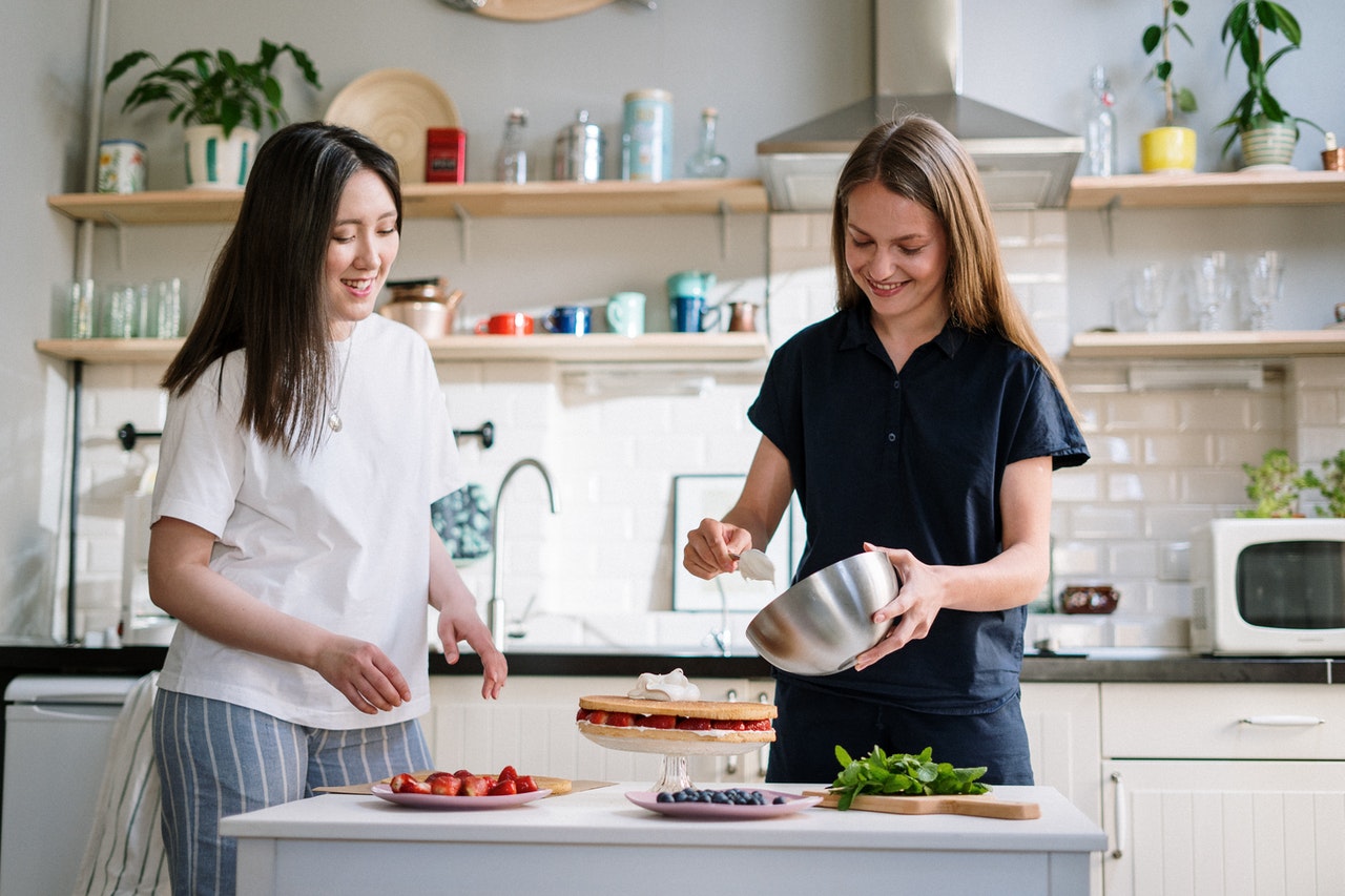 2 woman preparing food in the kitchen