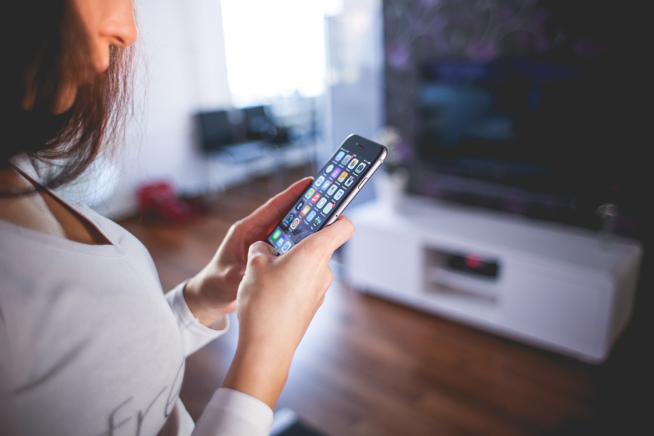 woman controlling smart home appliances in a smartphone