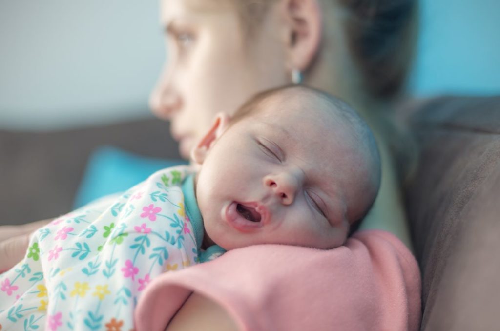 baby sleeping on mother's shoulder