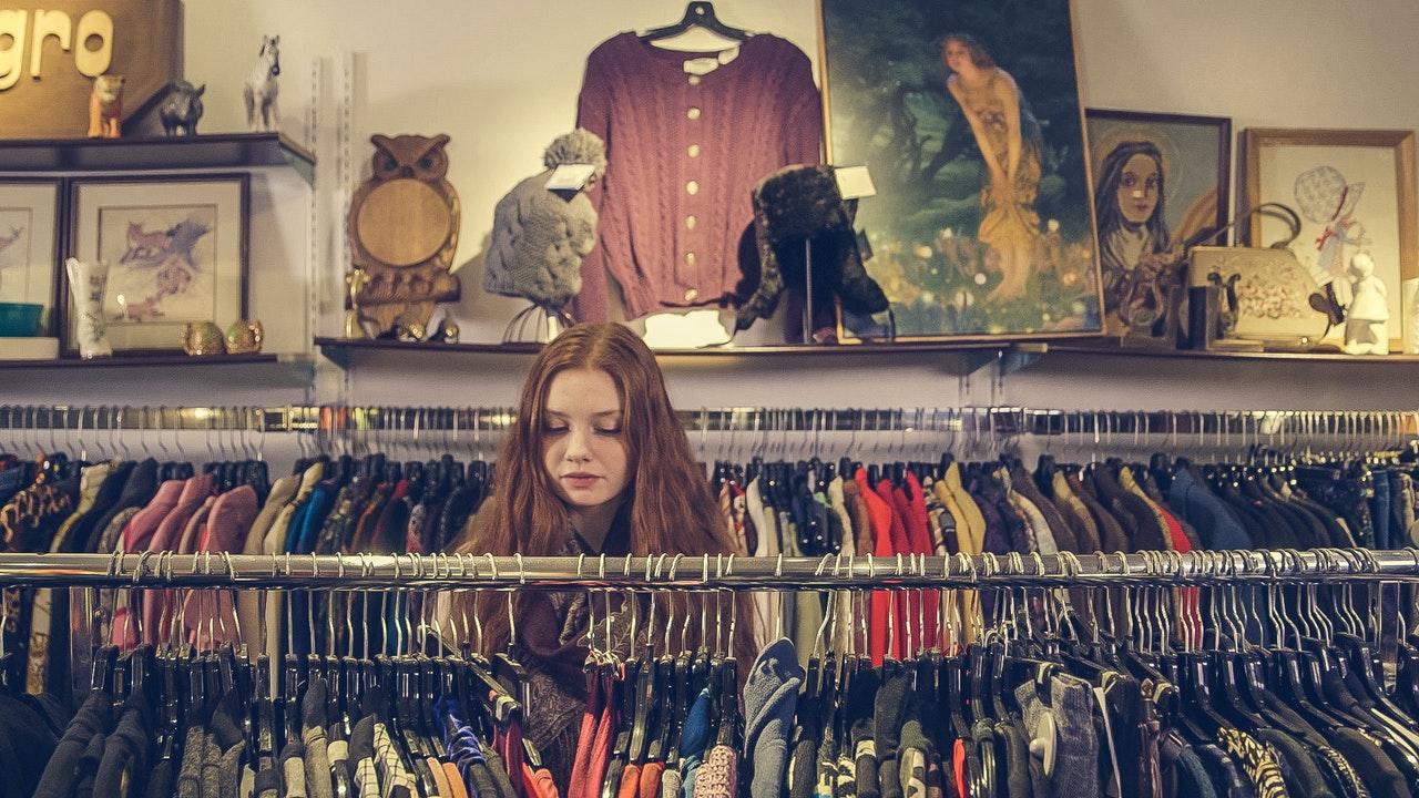 woman looking at clothing in thrift store