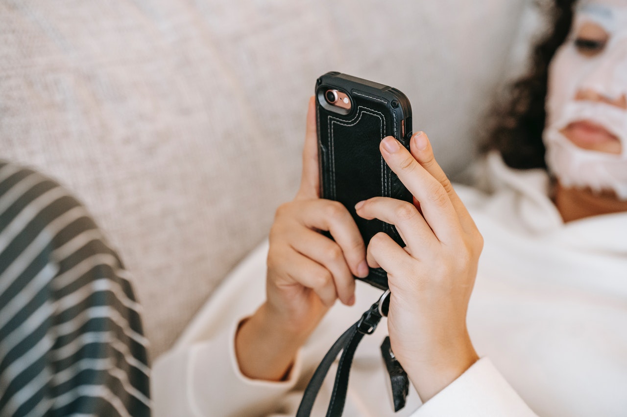 woman laying down using her phone