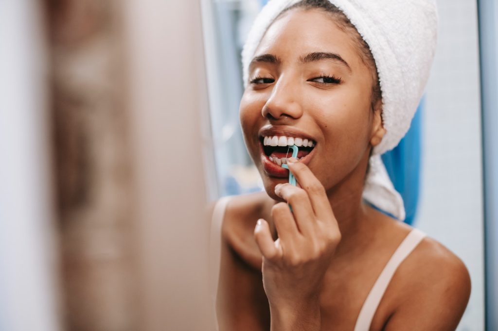 woman with perfect teeth flossing