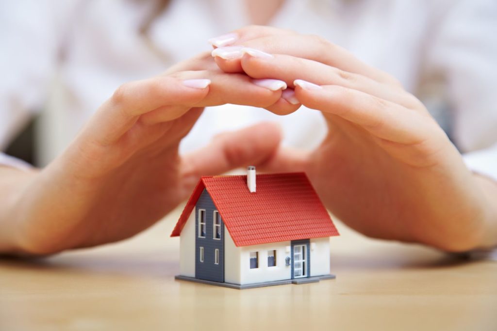 hand hovering over miniature house