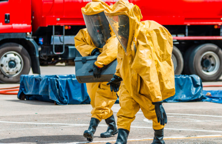 two person transporting hazardous chemical waste