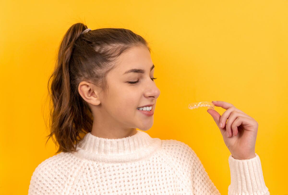 woman holding invisible braces