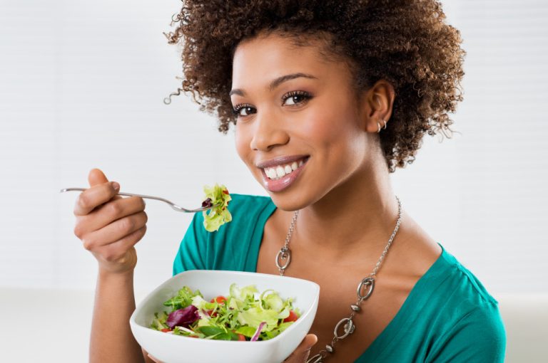 mixed race woman eating salad