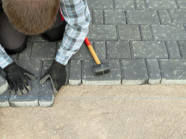 man laying down bricks