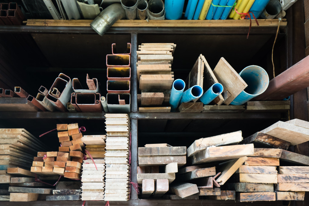 Construction materials like pipes and wood planks on a large shelf