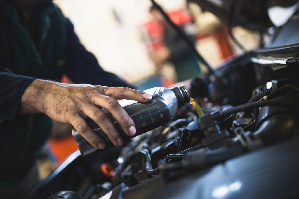 mechanic changing the oil of a car