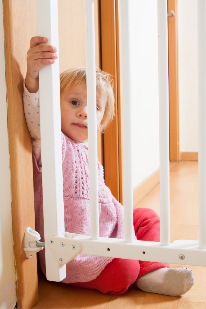 Baby sitting beside safety gate