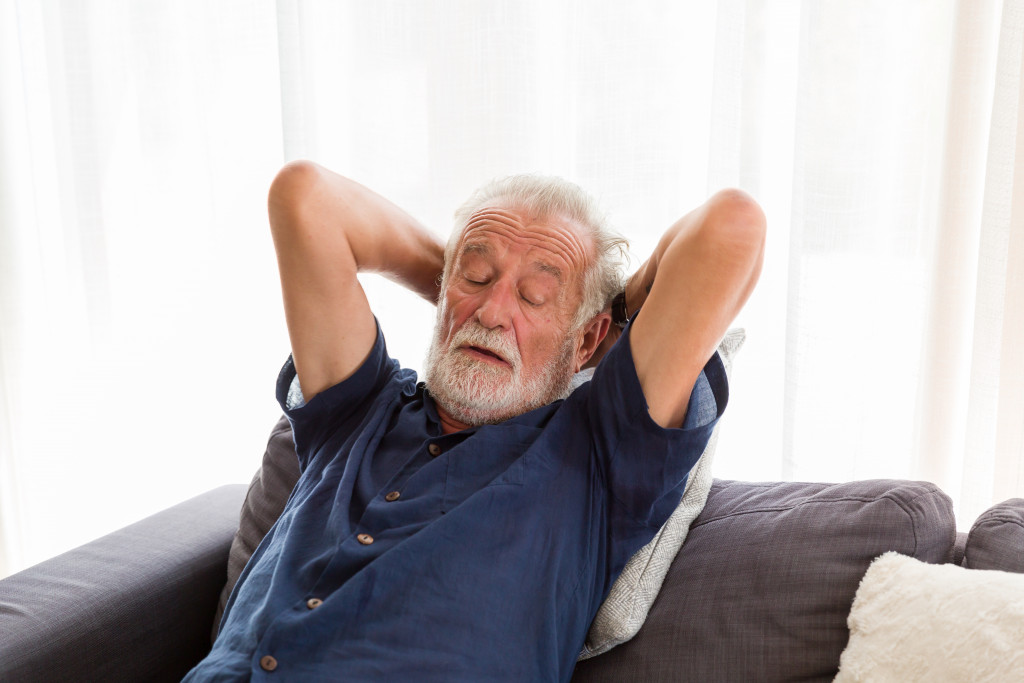 a senior man taking a nap on a sofa