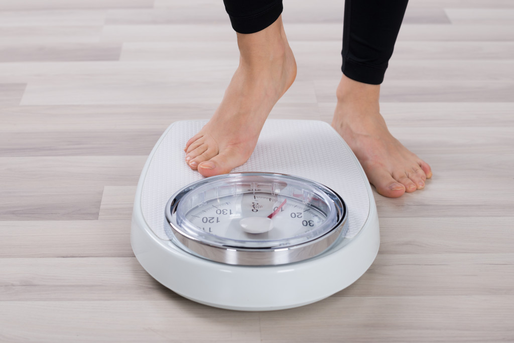 Low Section Of Person Standing On Weighing Scale