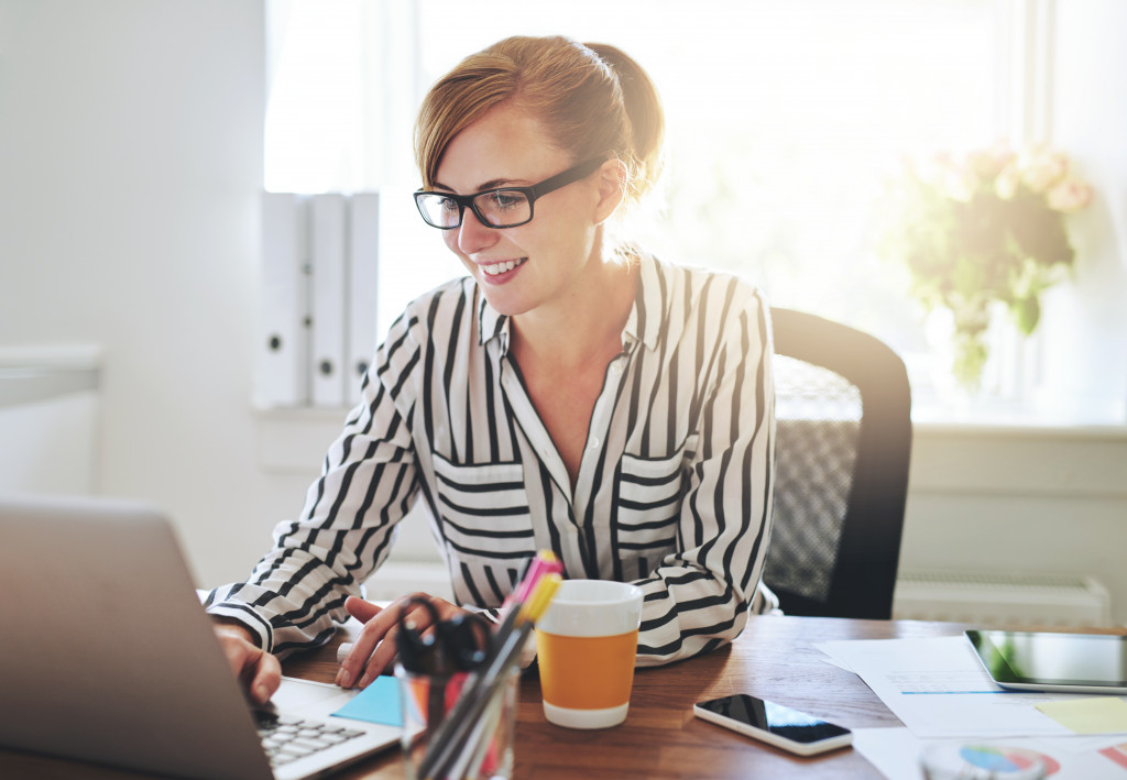 Successful female entrepreneur with a new online business working from home on her computer typing in a computer