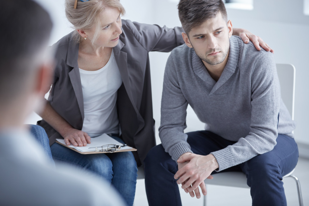 A woman consoling a patient in a support group setting