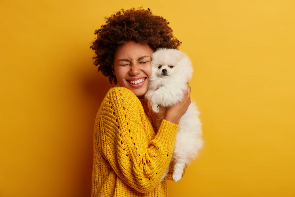 A pet owner hugging her dog