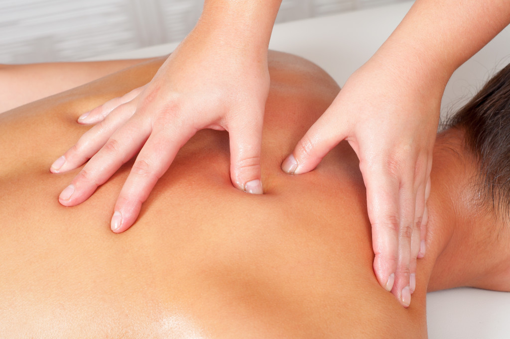 Young women getting back massage in massage salon.