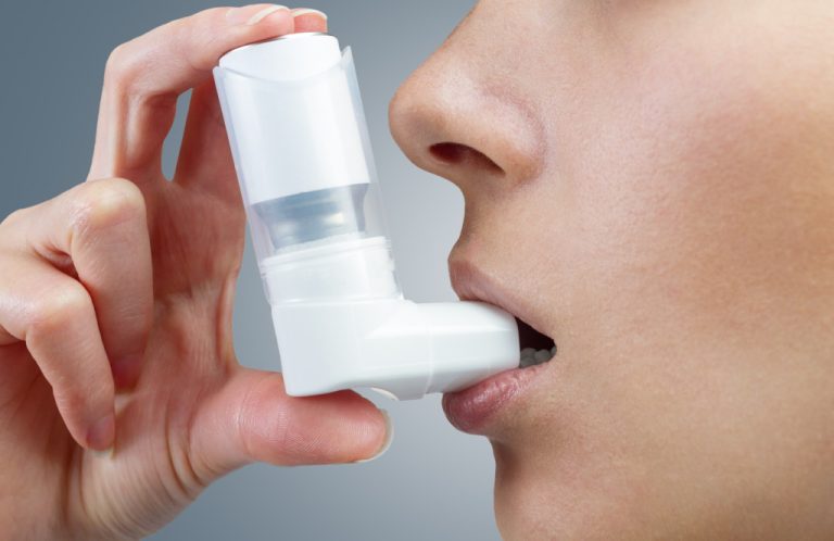 A girl using an inhaler during an asthma attack