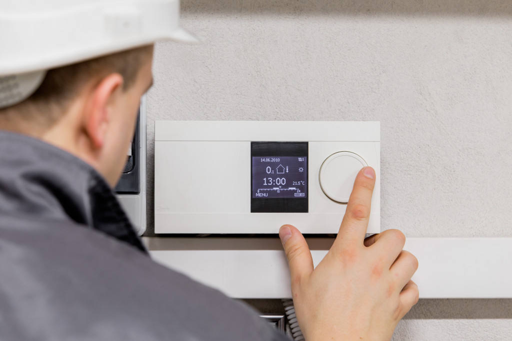 An HVAC maintenance worker is checking the HVAC control screen.