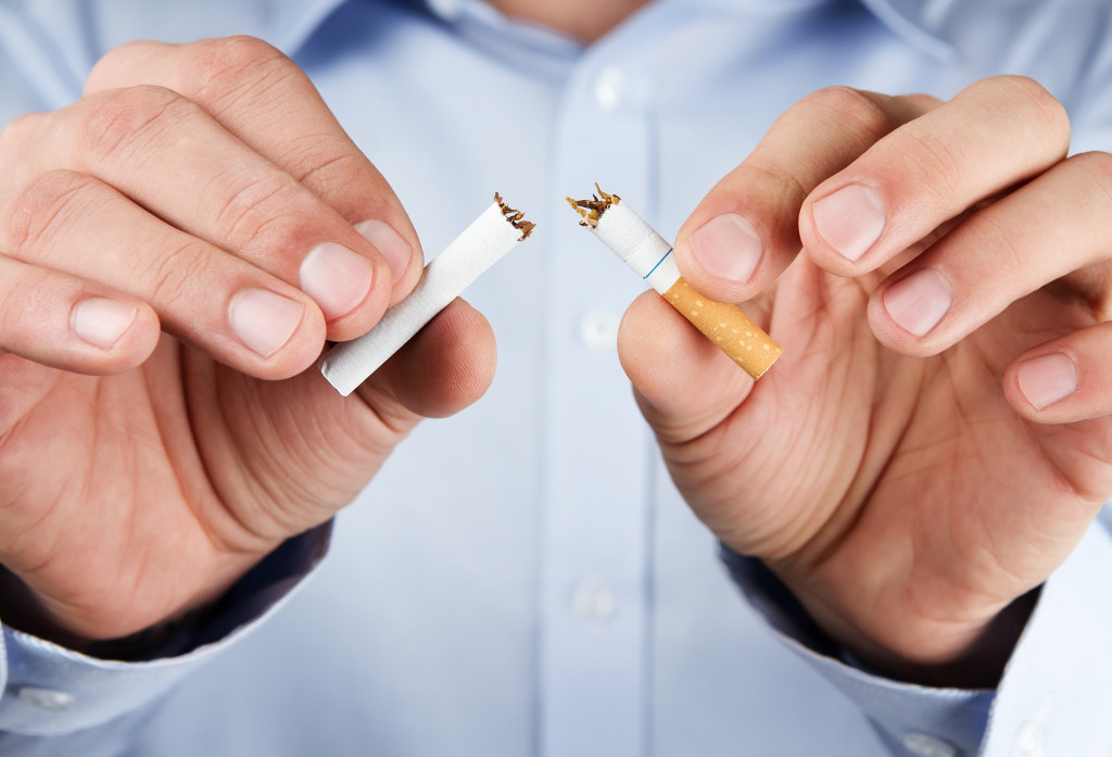 A person breaking a cigarette in two