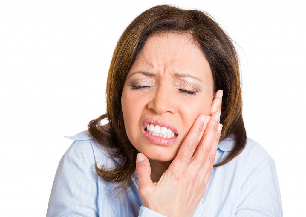 A woman feeling pain because of impacted wisdom tooth